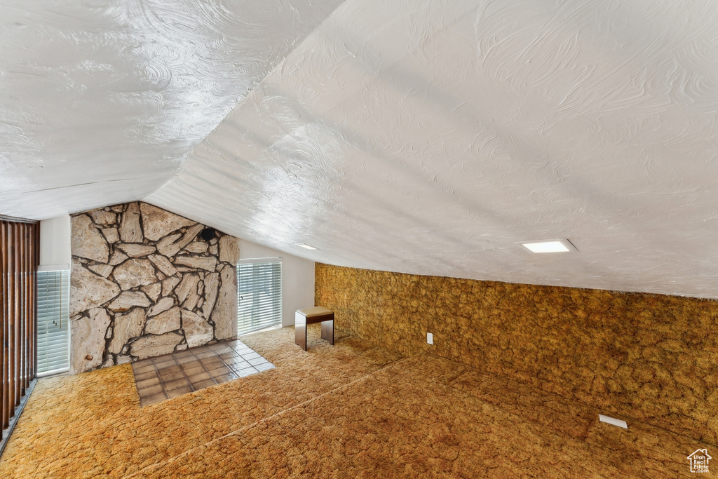 Additional living space featuring a textured ceiling and lofted ceiling