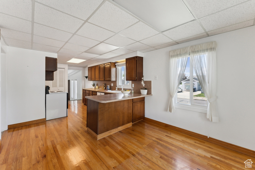 Kitchen with a sink, a paneled ceiling, a peninsula, and range