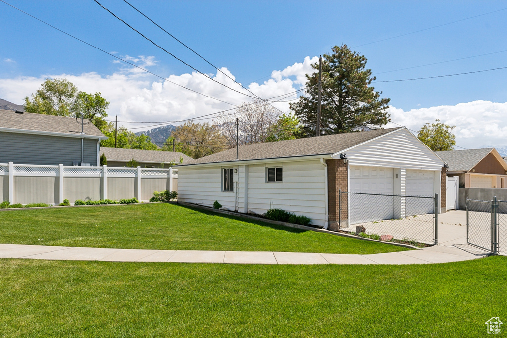 Exterior space with fence, a gate, and a garage