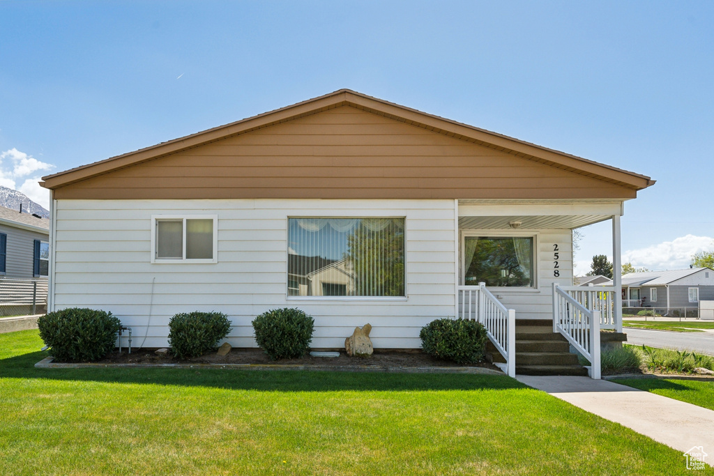 Bungalow featuring a porch and a front lawn