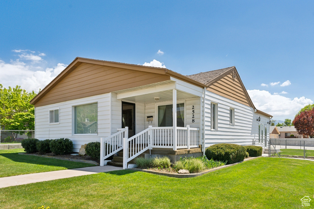 Bungalow-style house with fence and a front yard