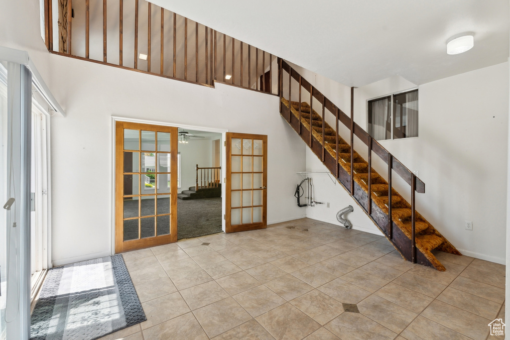 Interior space with light tile patterned floors, plenty of natural light, french doors, and stairs