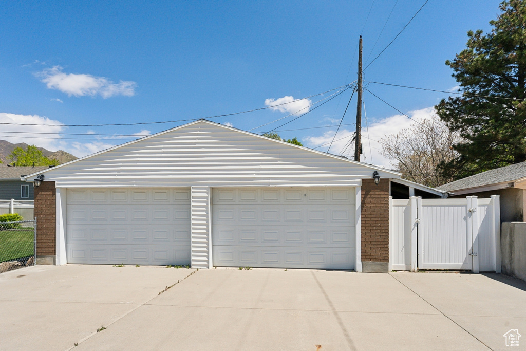 Detached garage featuring a gate and fence