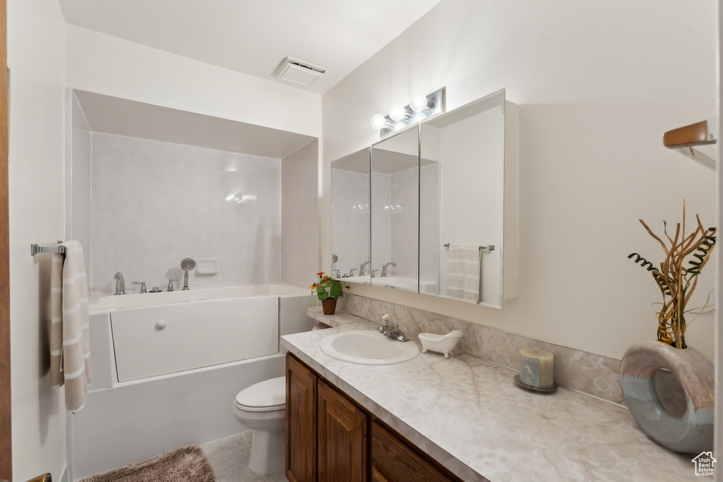 Bathroom with toilet, visible vents, a bathtub, and vanity