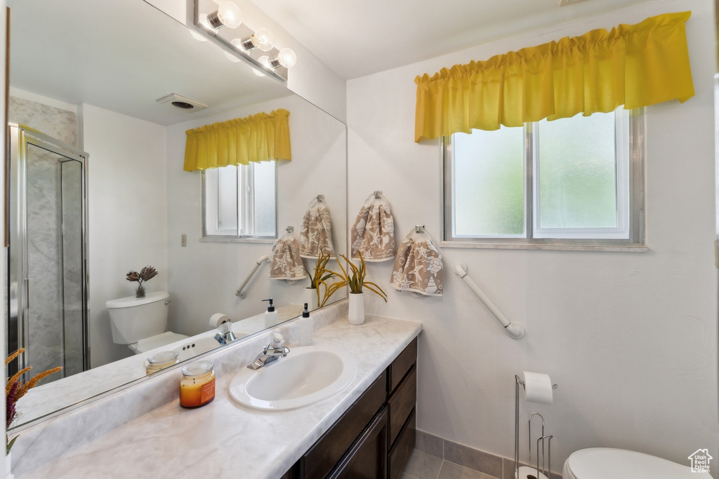 Bathroom with vanity, tile patterned floors, toilet, and a shower stall