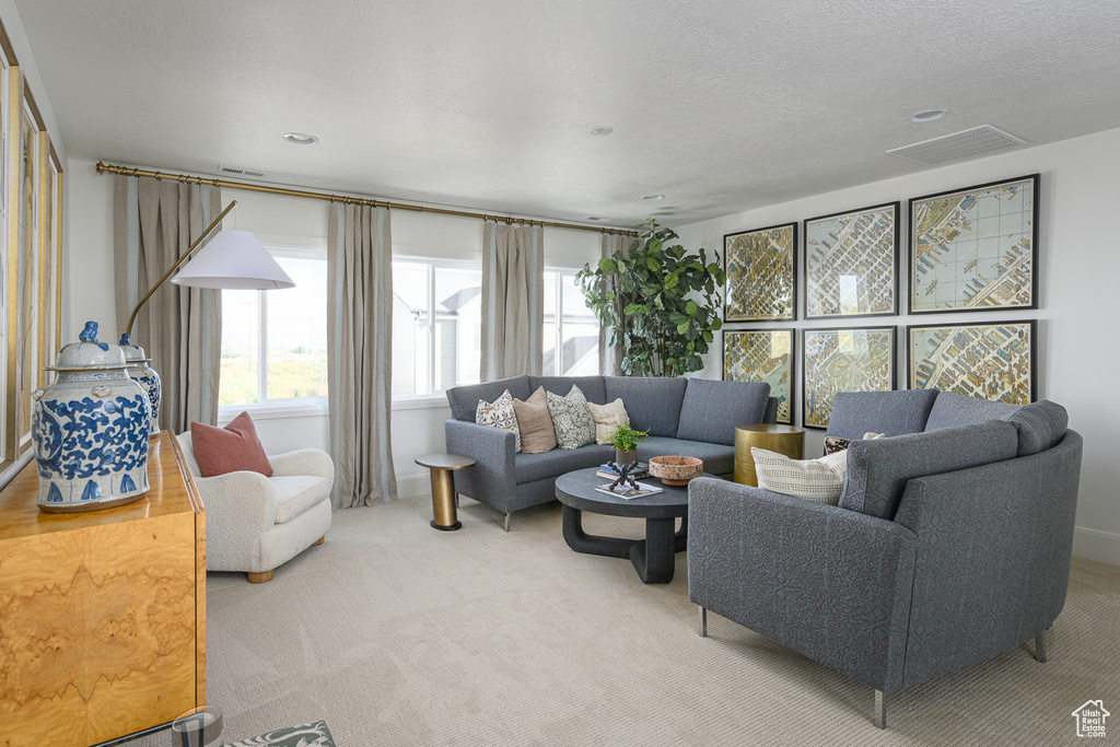 Living area with light colored carpet and visible vents