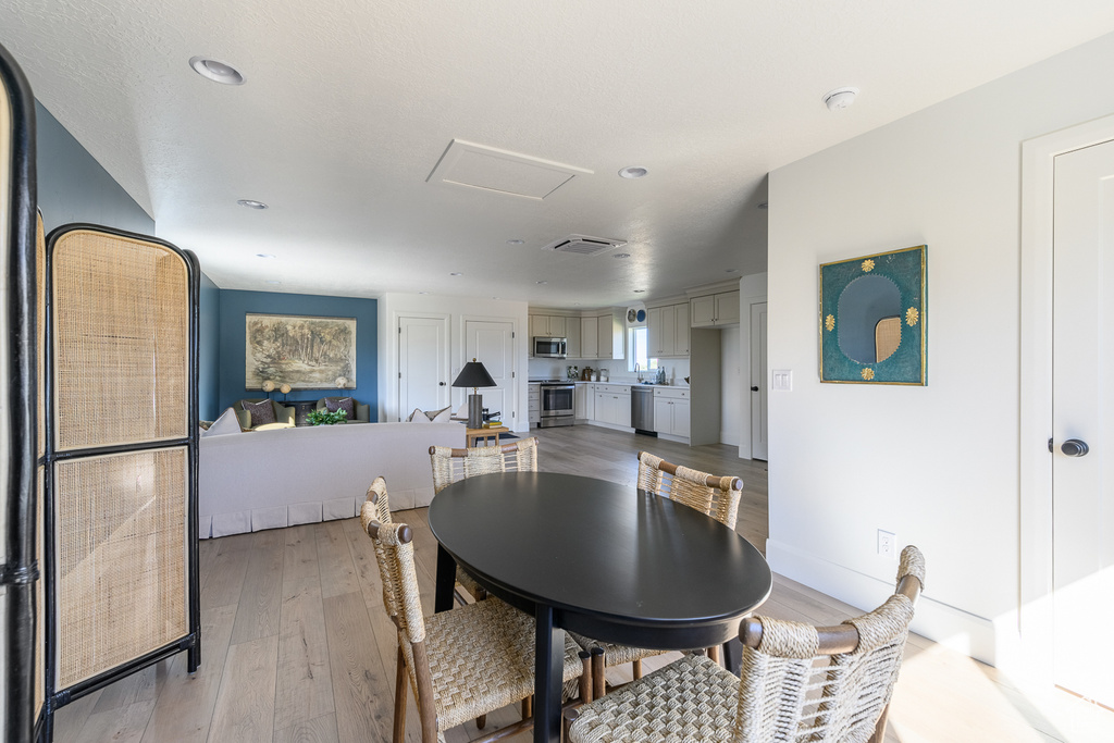 Dining space with attic access, recessed lighting, light wood-style flooring, and visible vents