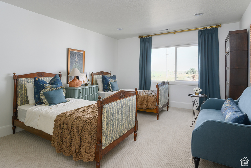 Bedroom featuring baseboards, light colored carpet, and visible vents
