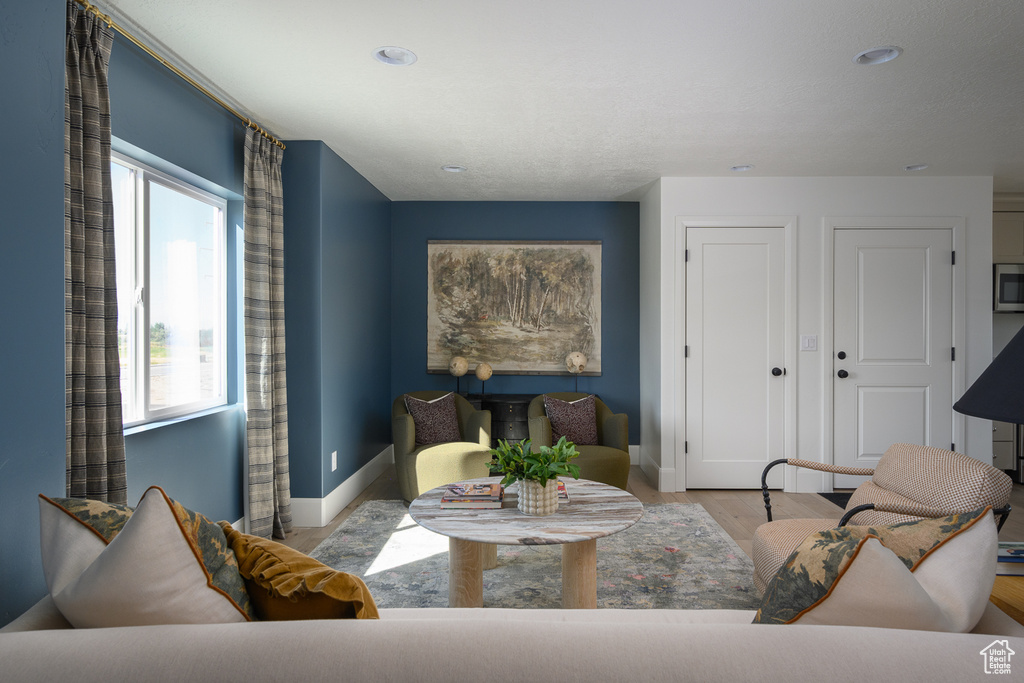 Living area featuring baseboards, recessed lighting, and wood finished floors