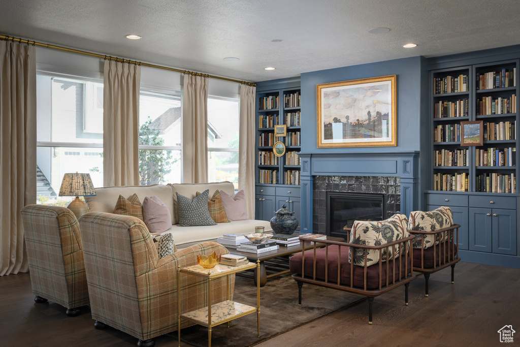 Living room featuring wood finished floors, a wealth of natural light, and a fireplace