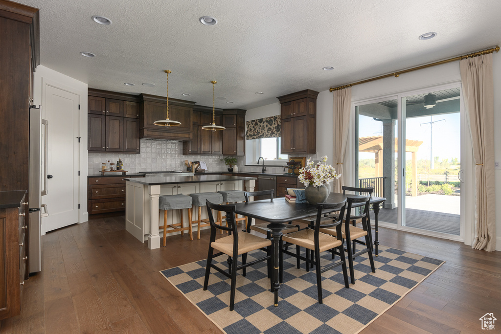 Dining room with recessed lighting, a textured ceiling, and dark wood-type flooring