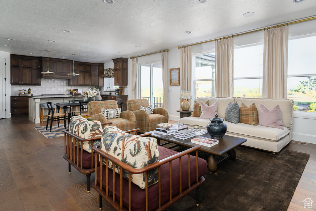 Living area featuring recessed lighting, baseboards, and dark wood-type flooring