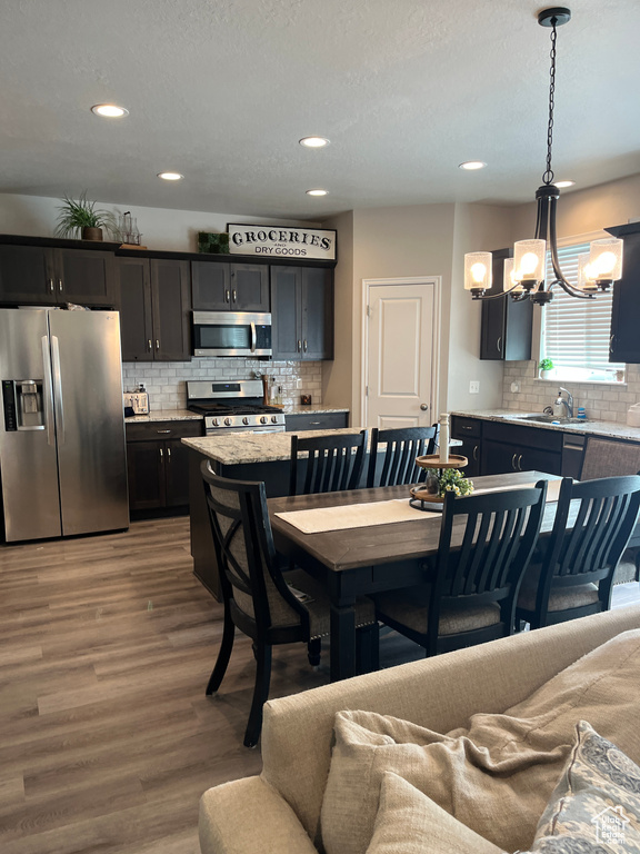 Dining area featuring recessed lighting, a notable chandelier, and wood finished floors