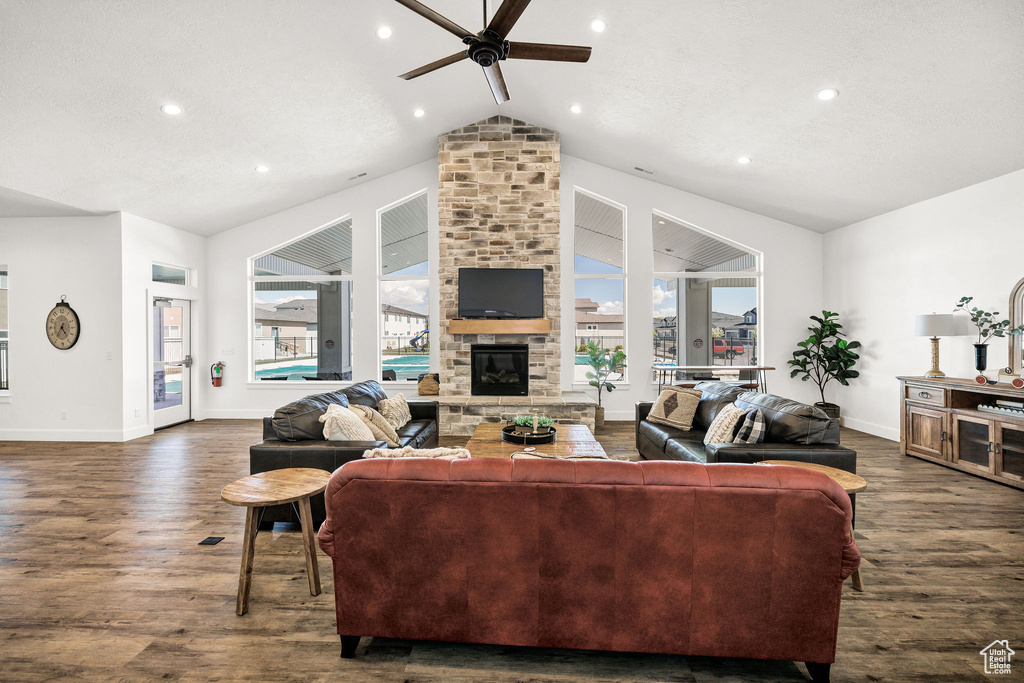 Living room featuring baseboards, a ceiling fan, dark wood-style flooring, and lofted ceiling