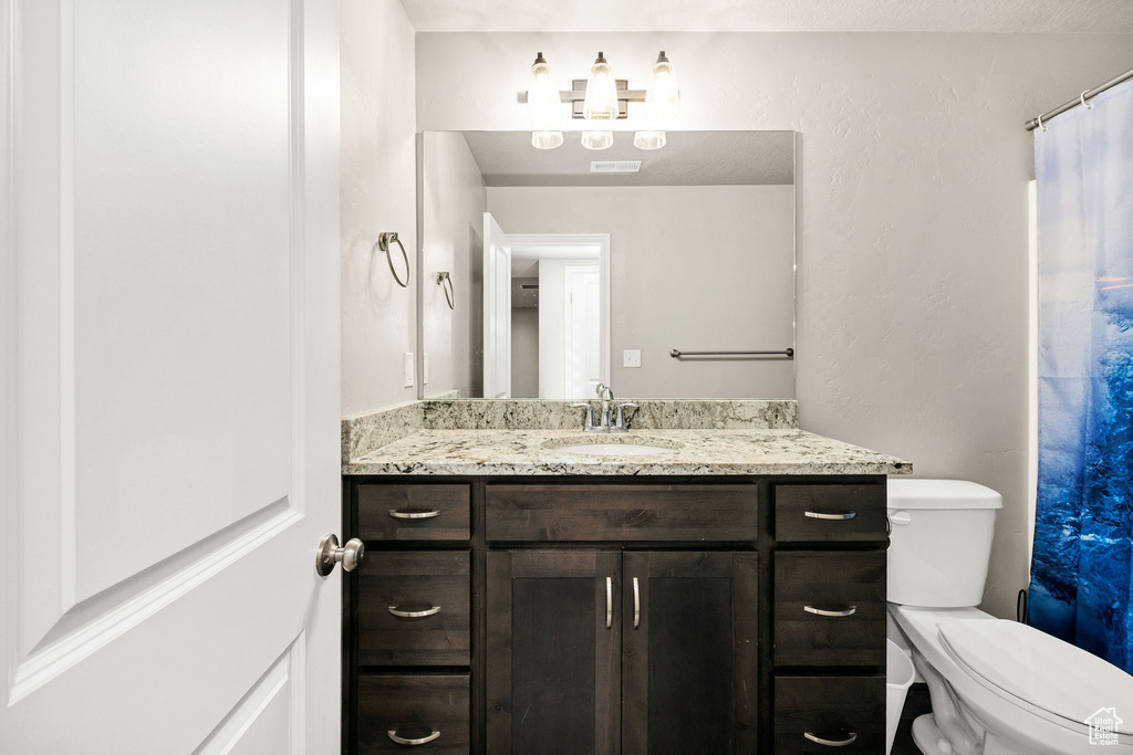 Bathroom with vanity, toilet, and visible vents