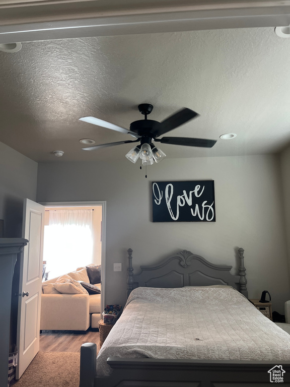 Bedroom featuring a textured ceiling, ceiling fan, and wood finished floors