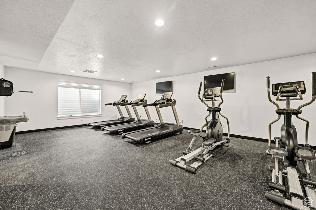 Workout area with baseboards, recessed lighting, a textured ceiling, and visible vents