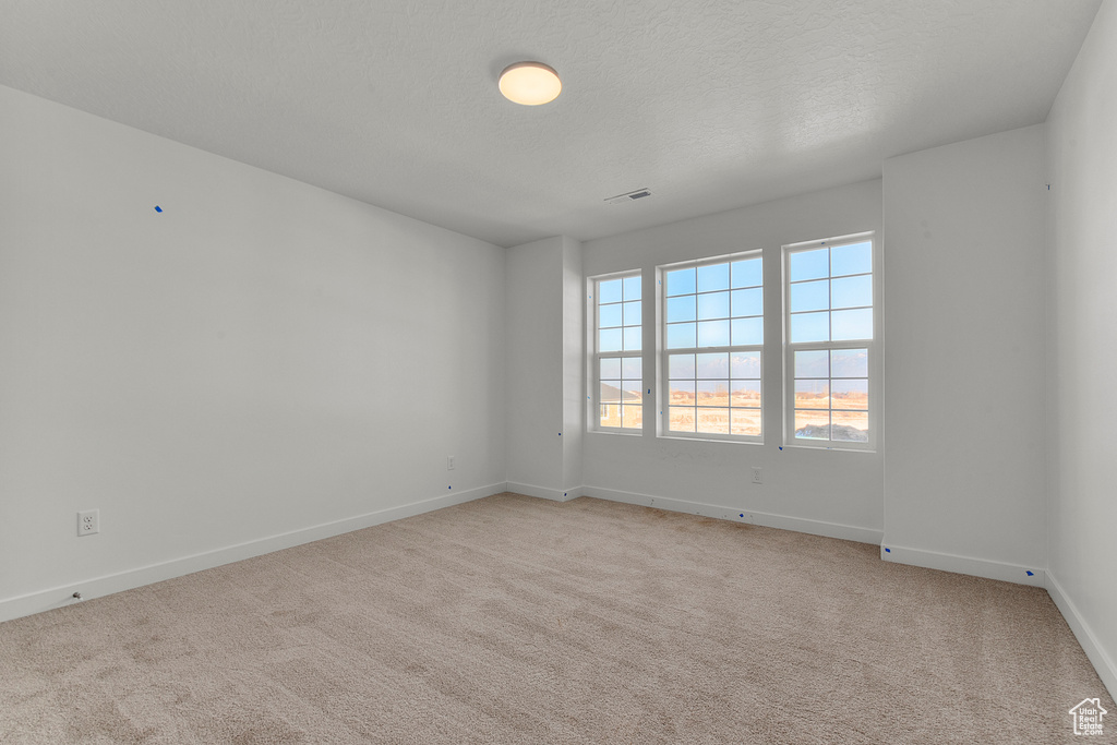 Empty room with baseboards and light carpet