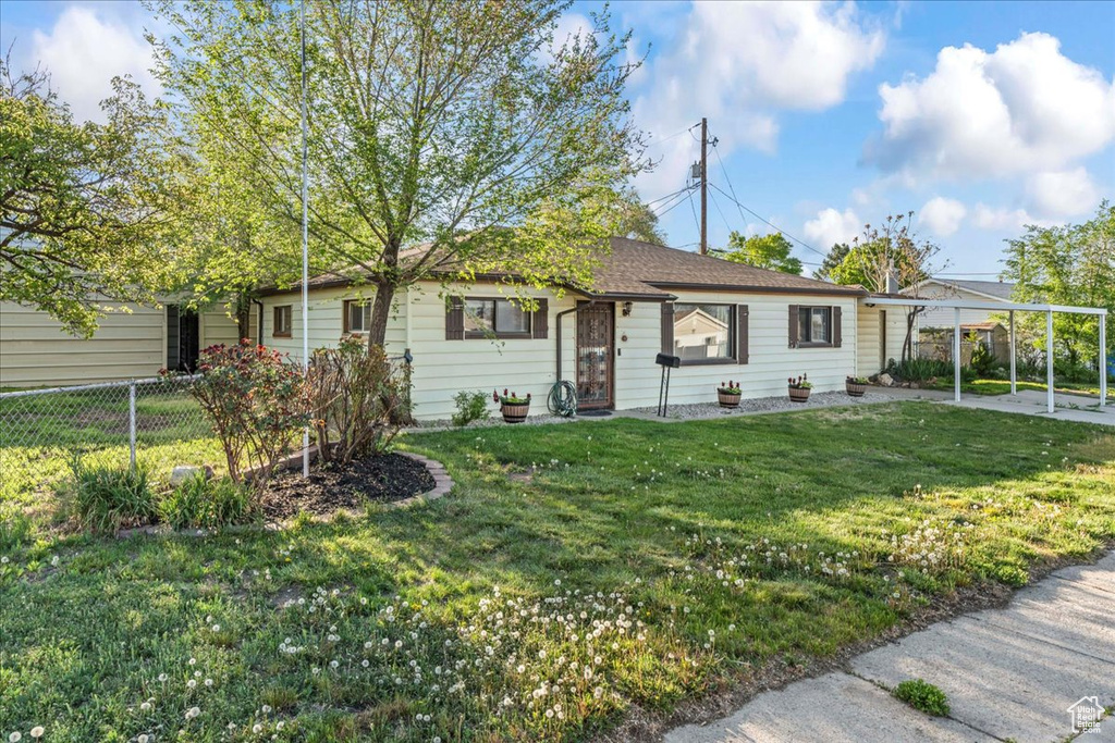 View of front facade with fence and a front lawn