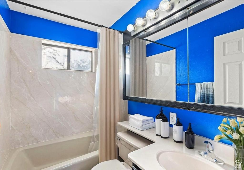Full bath with toilet, shower / bath combo, and vanity