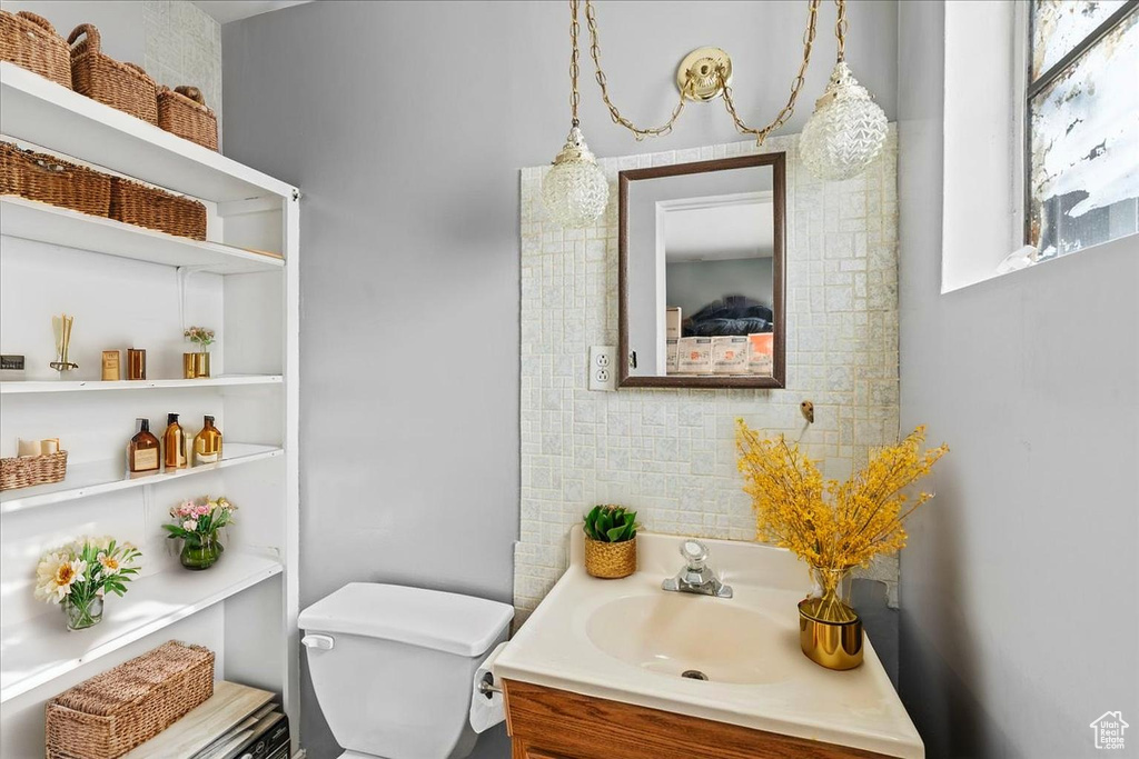 Bathroom featuring toilet, tasteful backsplash, and vanity