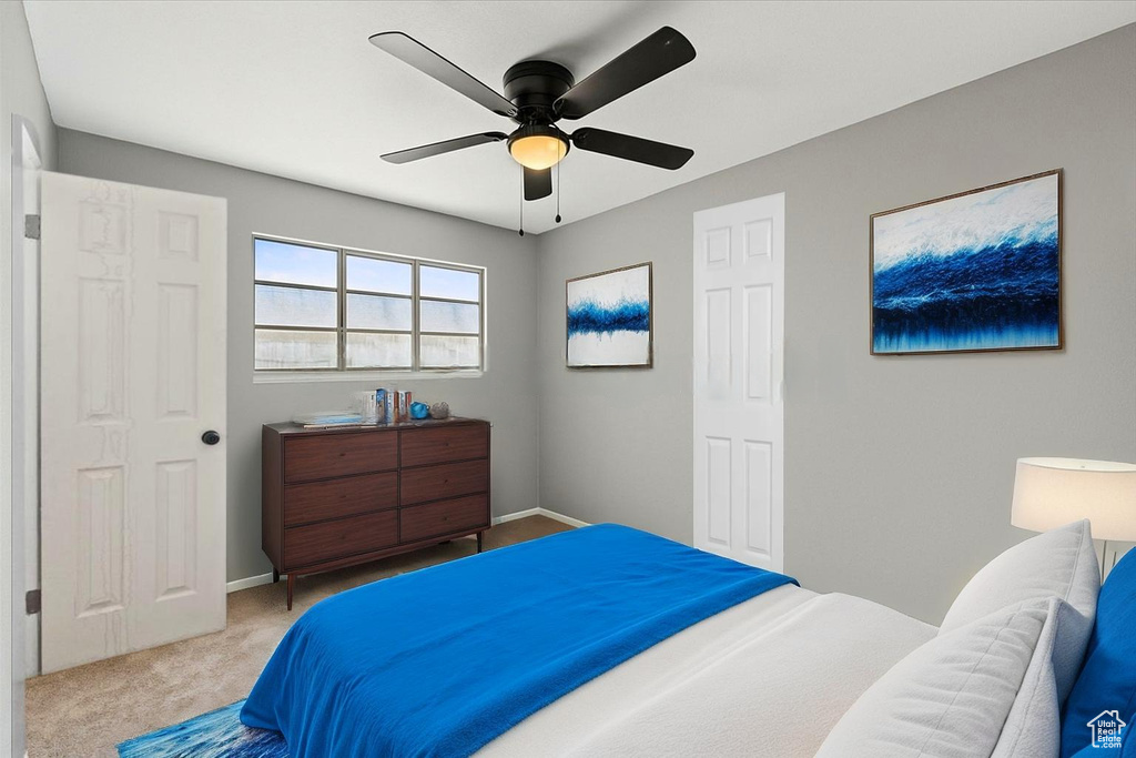 Carpeted bedroom with baseboards and a ceiling fan