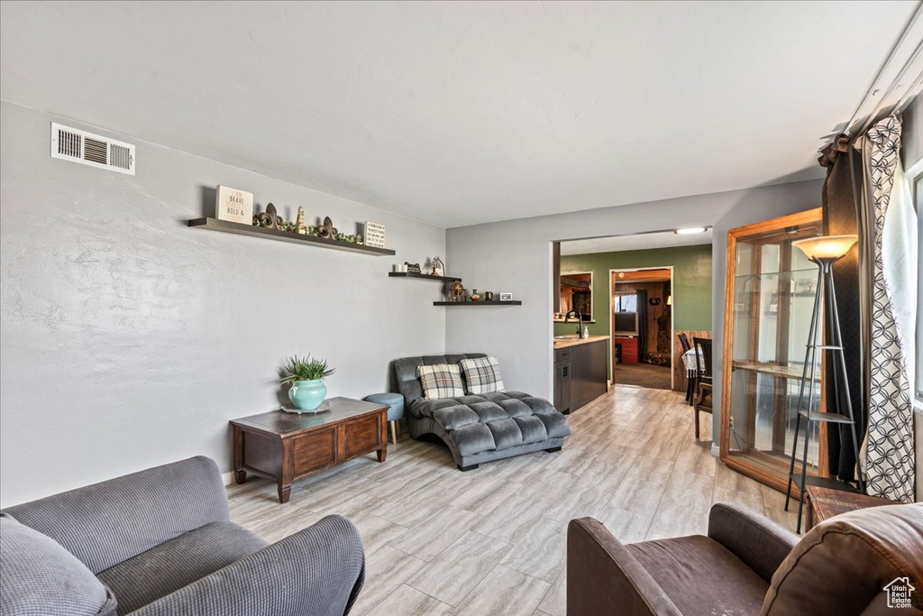 Living area featuring light wood-style flooring and visible vents