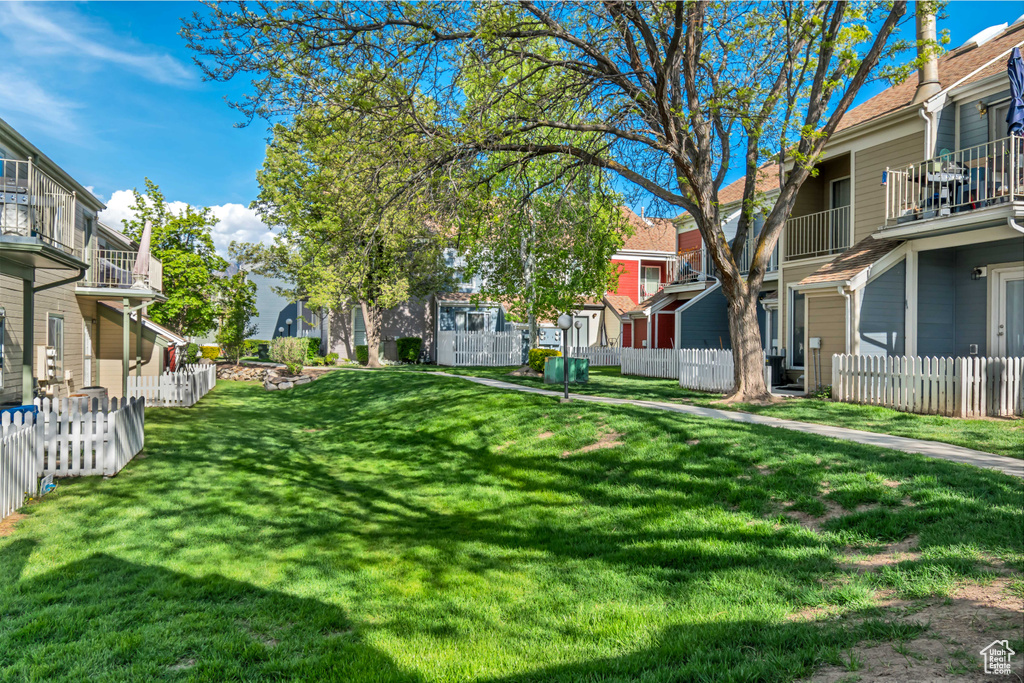 View of property's community featuring a yard, fence, and a residential view