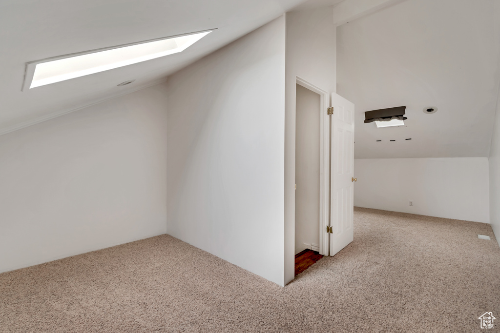 Bonus room featuring carpet flooring and vaulted ceiling with skylight