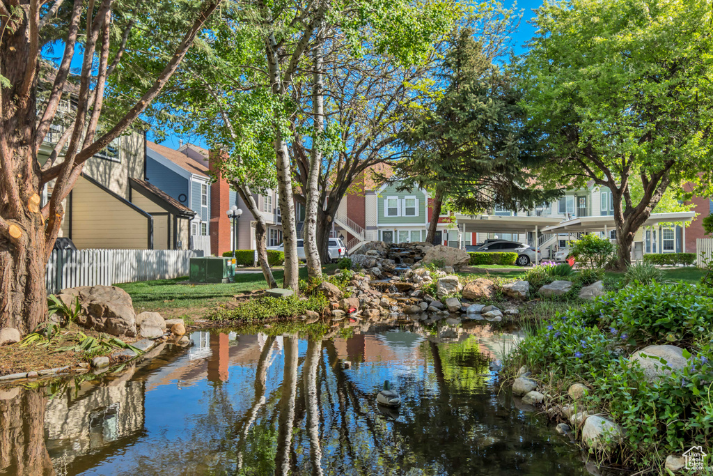 Water view featuring fence, a residential view, and a garden pond