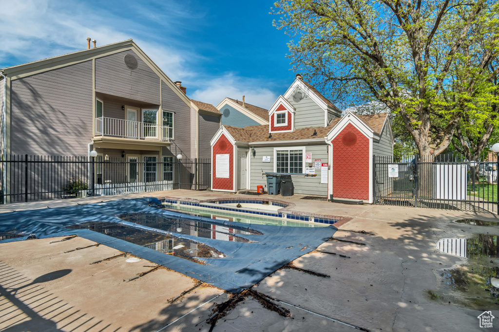 Rear view of property with a community pool, a patio area, and fence