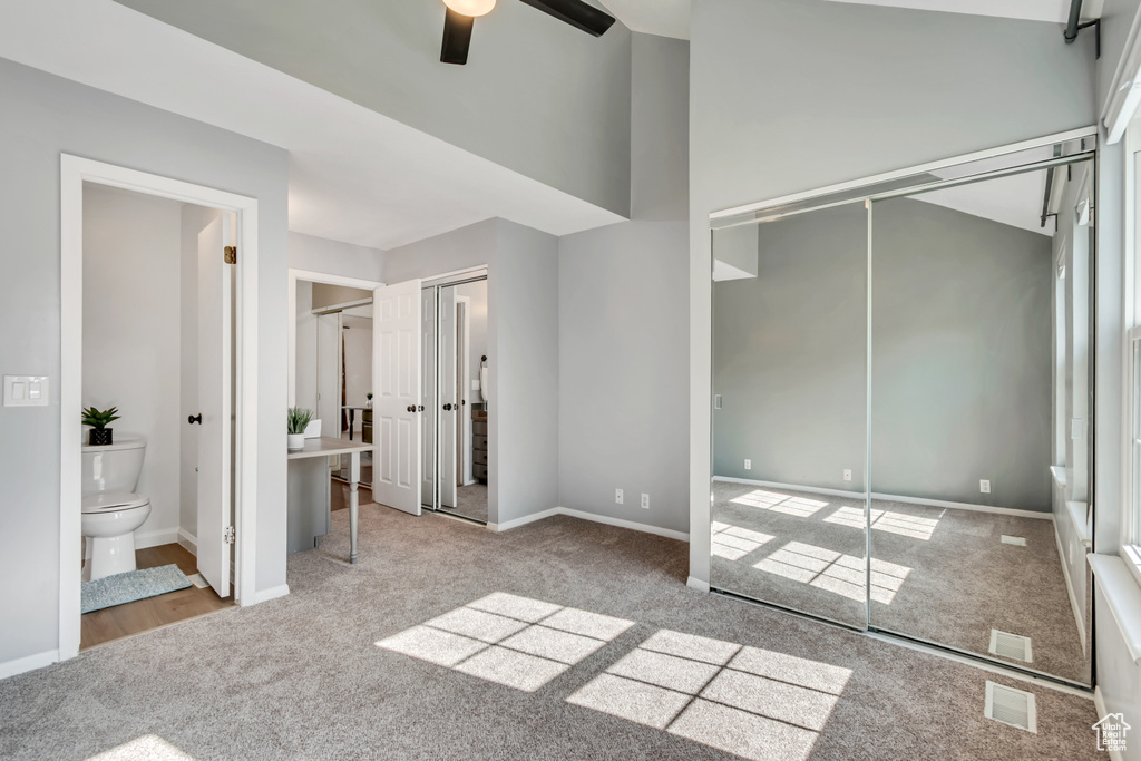 Unfurnished bedroom featuring visible vents, carpet floors, baseboards, two closets, and connected bathroom