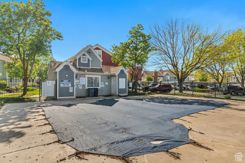 View of front of property with fence, a gate, and a residential view