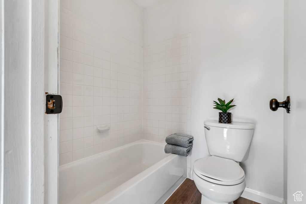 Bathroom with baseboards, toilet, and wood finished floors