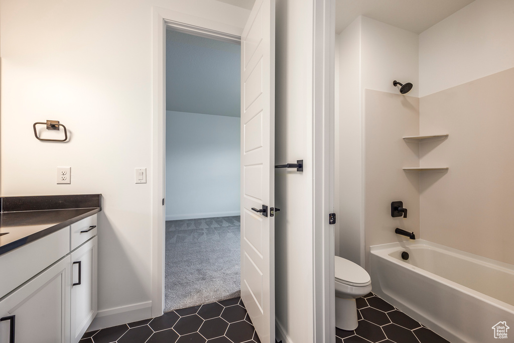 Bathroom featuring vanity, tile patterned floors, shower / bathtub combination, and toilet