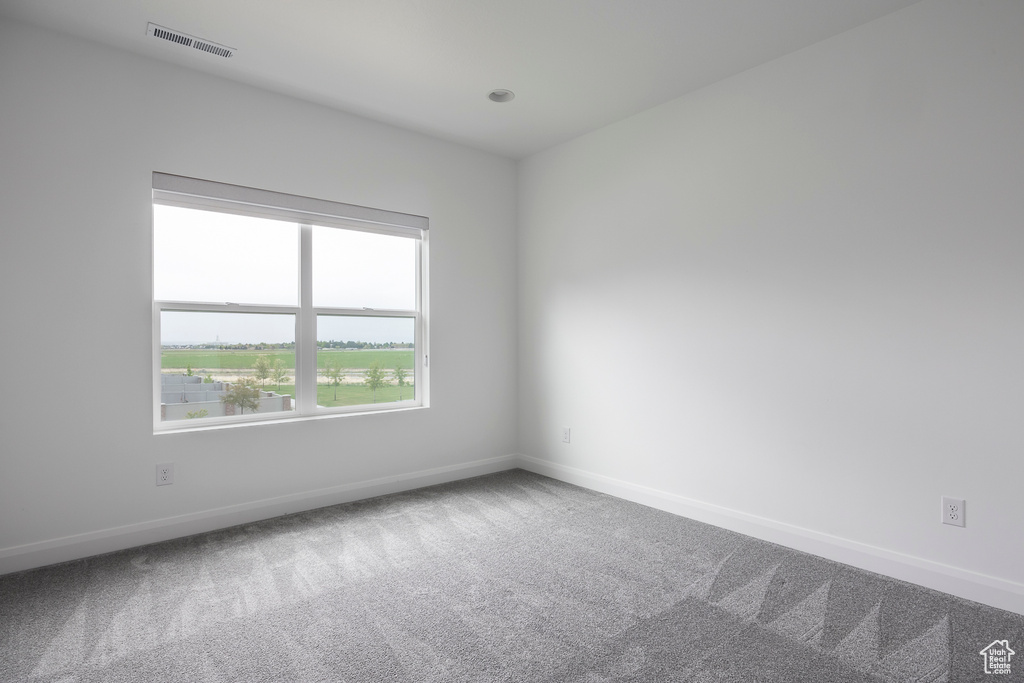 Carpeted spare room with baseboards and visible vents