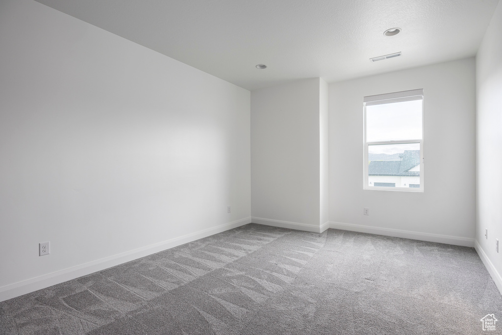 Unfurnished room featuring carpet floors, baseboards, recessed lighting, and visible vents