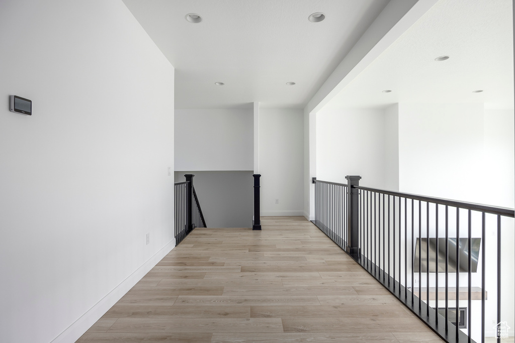 Corridor featuring recessed lighting, light wood-type flooring, and an upstairs landing
