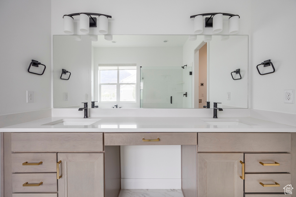 Bathroom featuring double vanity, a sink, marble finish floor, and a shower stall