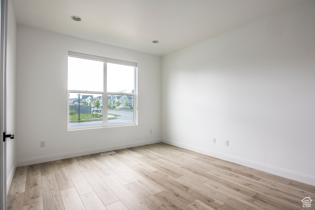 Empty room featuring baseboards and light wood-style flooring