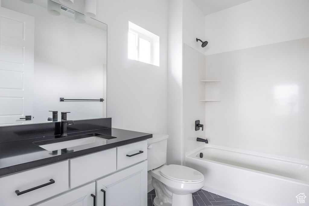 Full bath with vanity, tile patterned floors, toilet, and tub / shower combination
