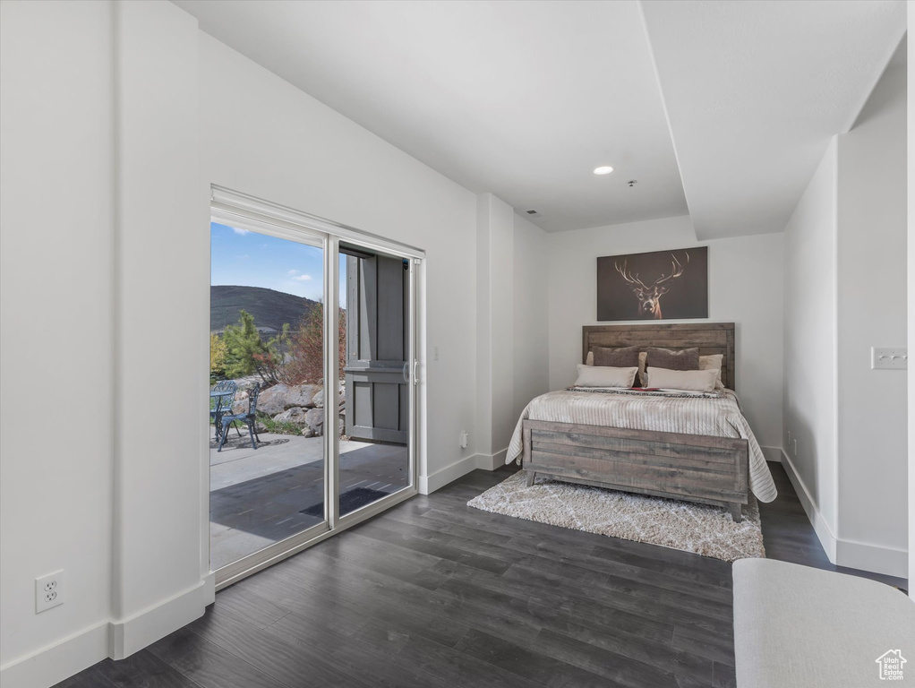 Bedroom with dark wood finished floors, baseboards, a mountain view, access to outside, and recessed lighting