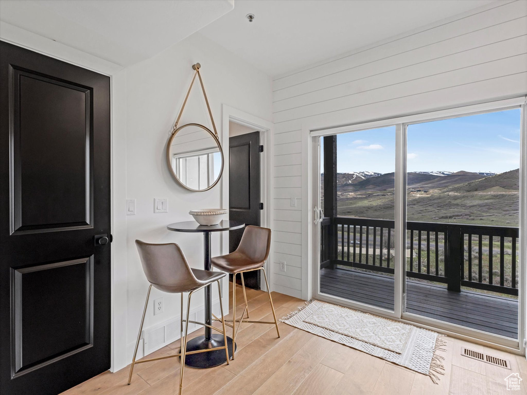 Dining space with wooden walls, visible vents, a mountain view, and wood finished floors
