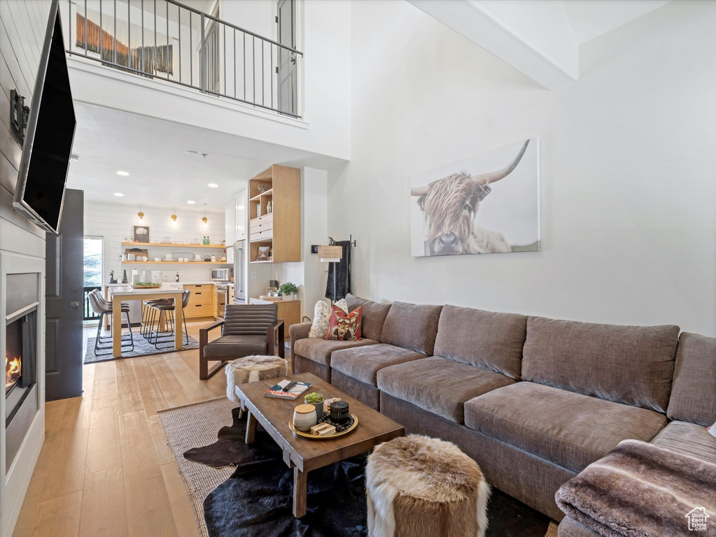 Living room featuring a glass covered fireplace, recessed lighting, and light wood finished floors
