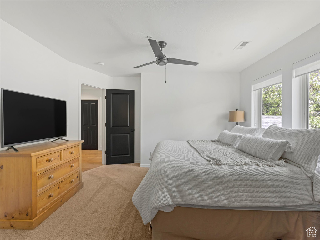 Bedroom with visible vents, baseboards, ceiling fan, and light carpet