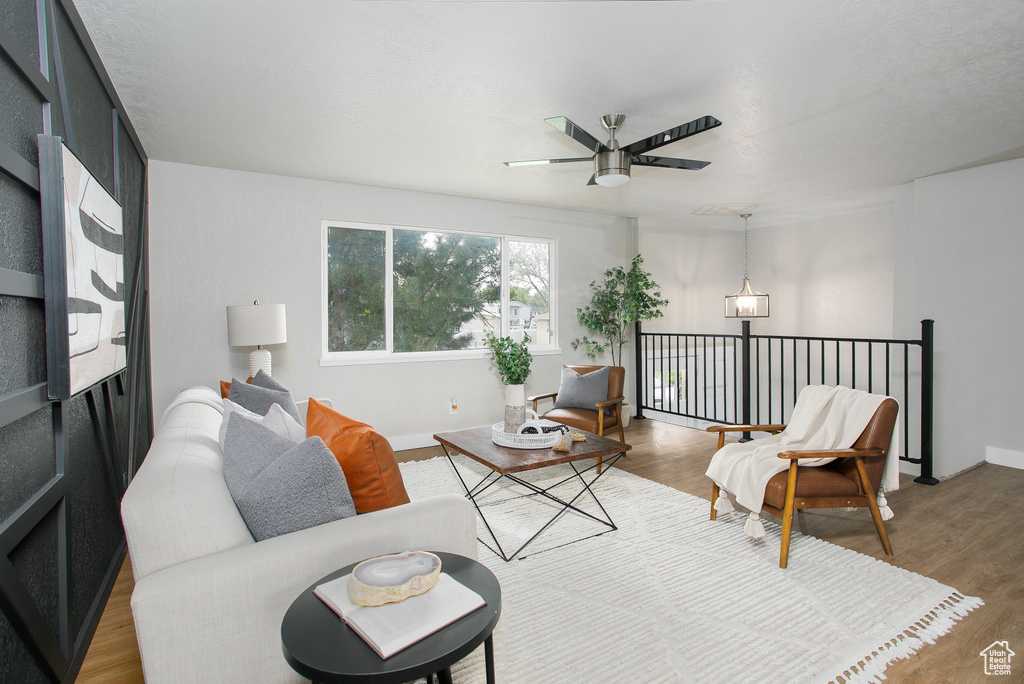Living room with baseboards, a ceiling fan, and wood finished floors