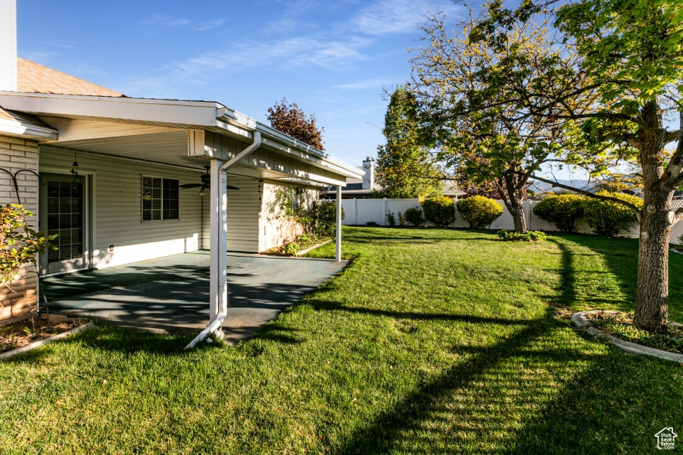 View of yard featuring fence and a patio