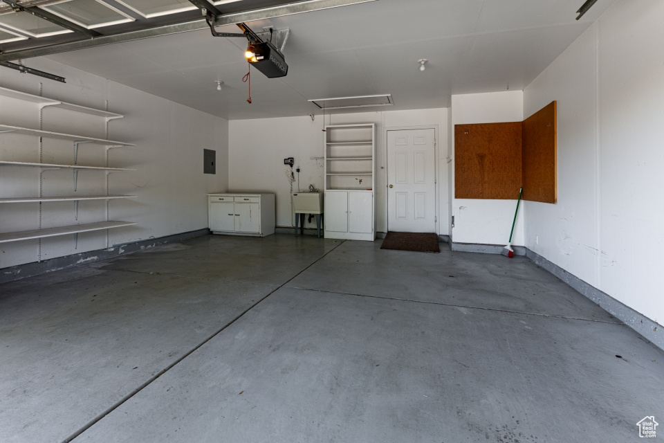 Garage featuring a garage door opener and a sink