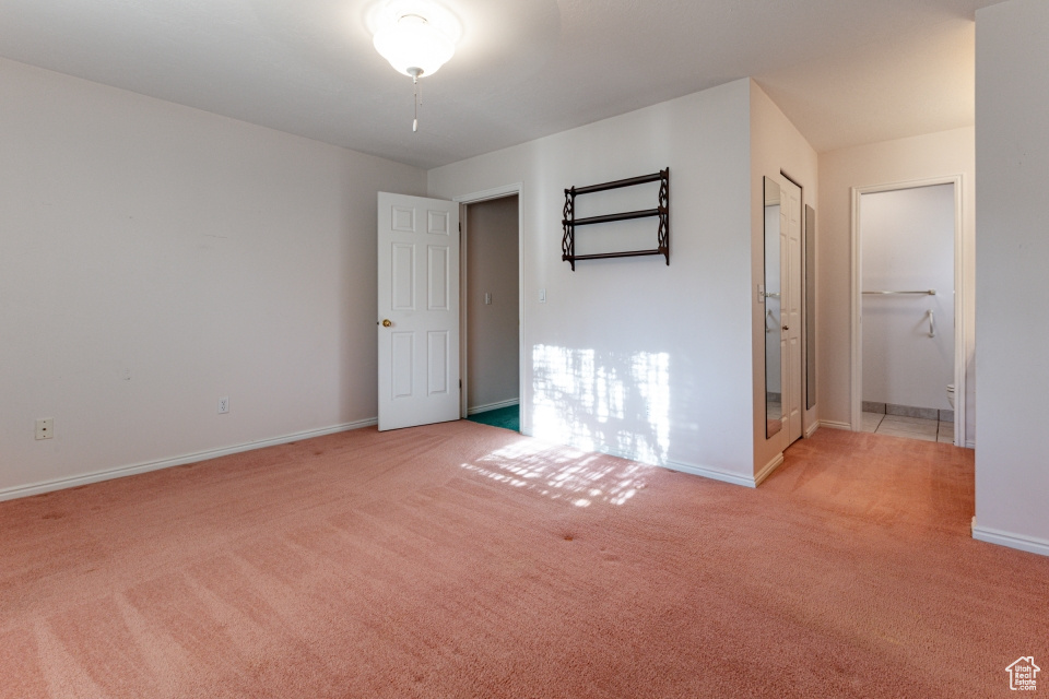 Unfurnished bedroom with baseboards and light colored carpet