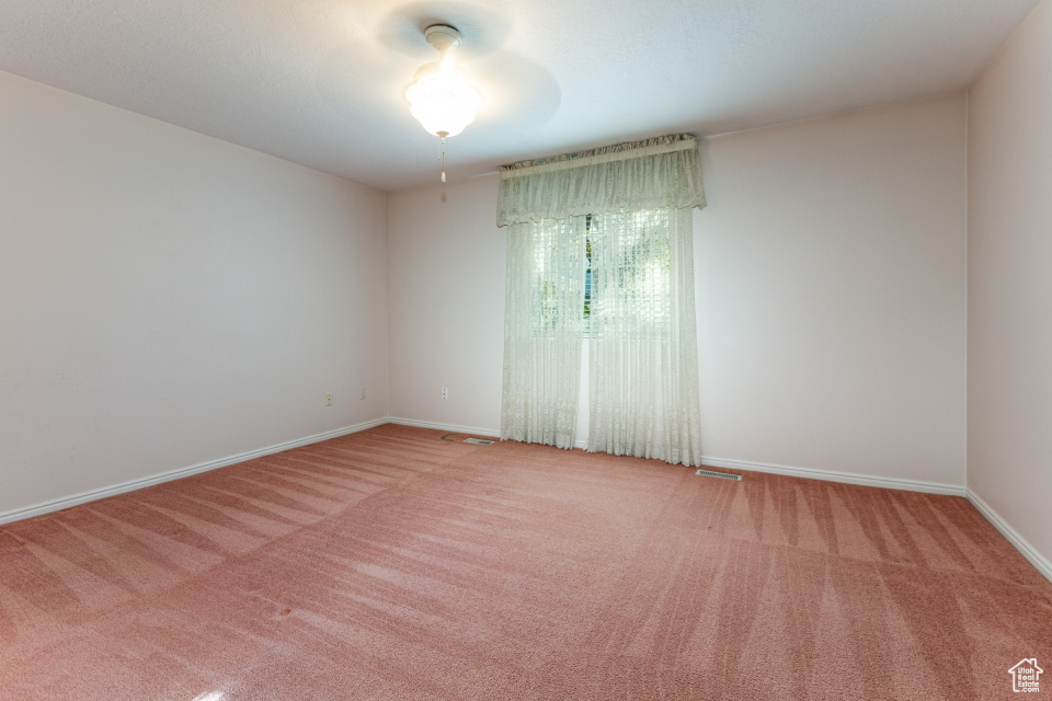 Empty room featuring baseboards and carpet